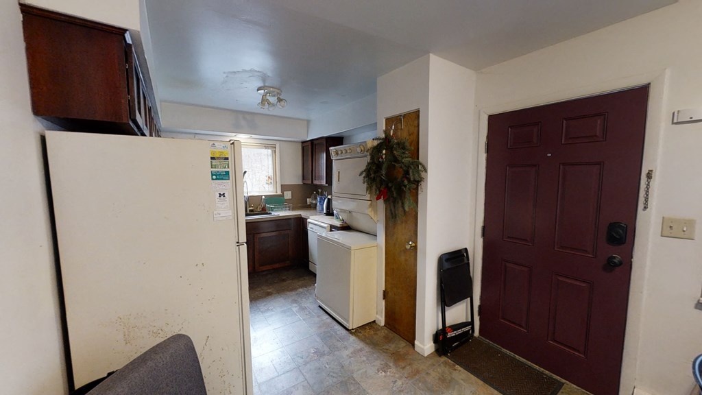 a kitchen with white appliances and a brown door